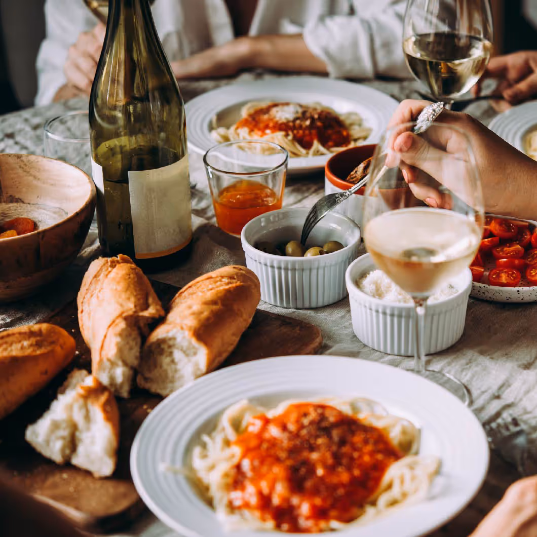 Foto von italienischer Pasta und Wein auf einem gedeckten Tisch